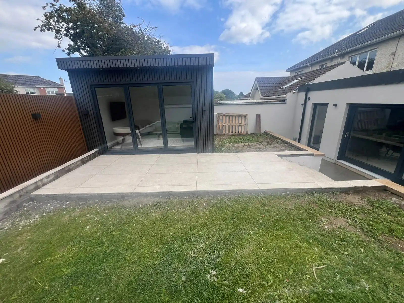 Completed porcelain patio beside a garden room